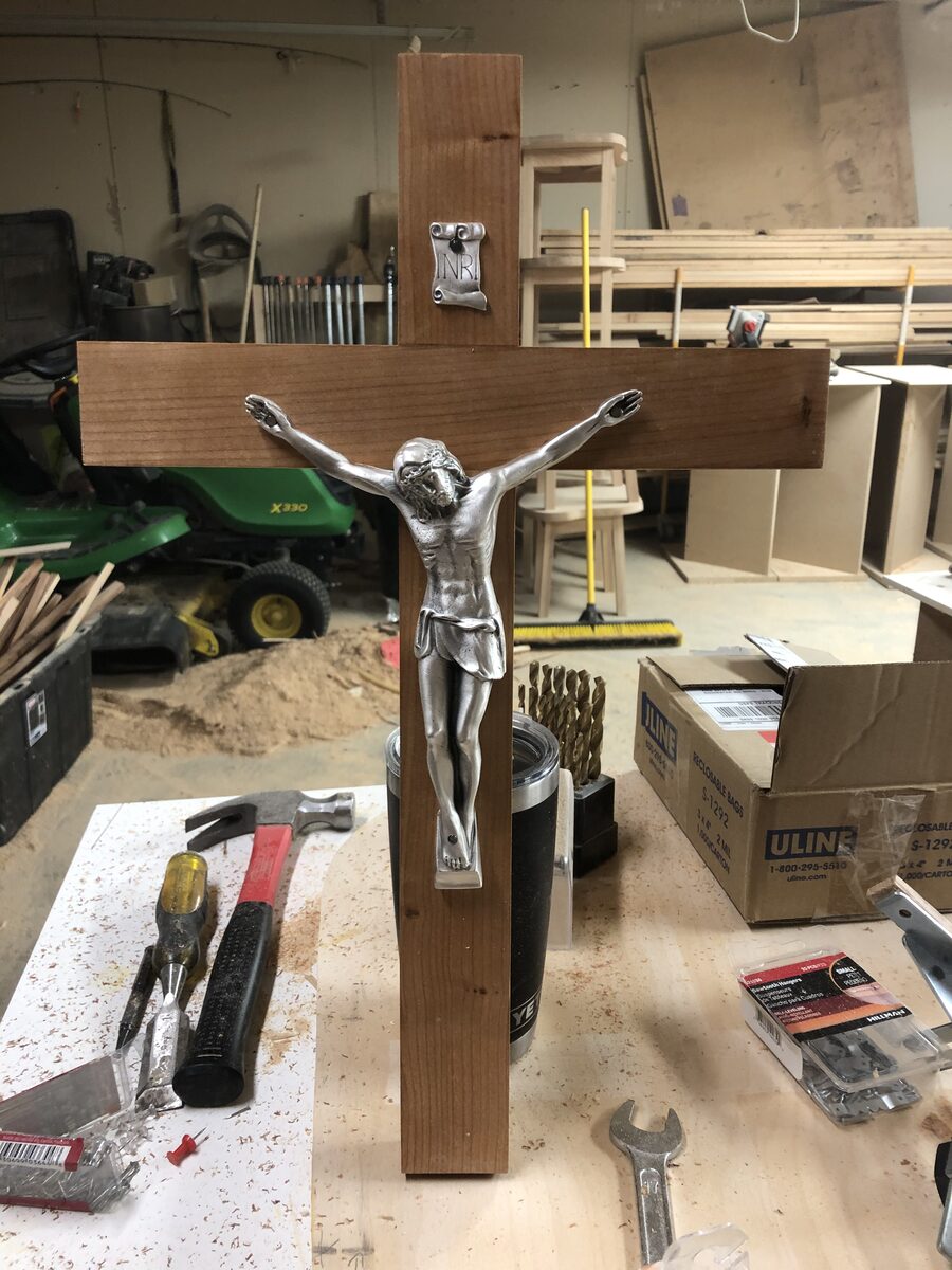 Crucifix with silver corpus on workbench in Mark's woodworking shop