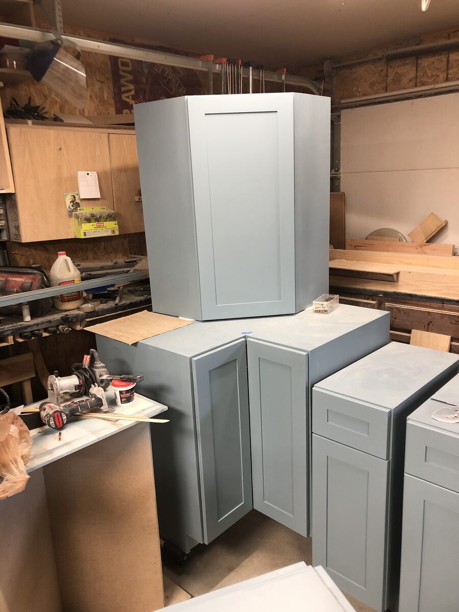 Custom painted shaker-style kitchen cabinets in light blue being built in the shop