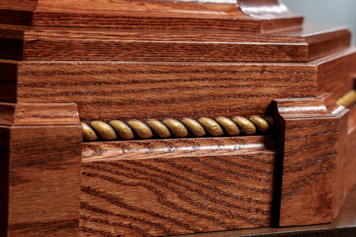 Detail of gold rope molding on baptismal font base in red oak